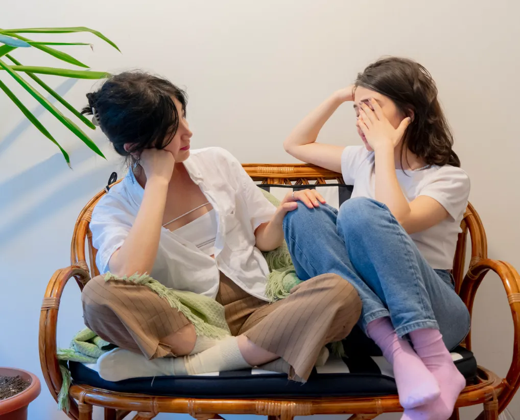 Two friends sitting close together in quiet conversation