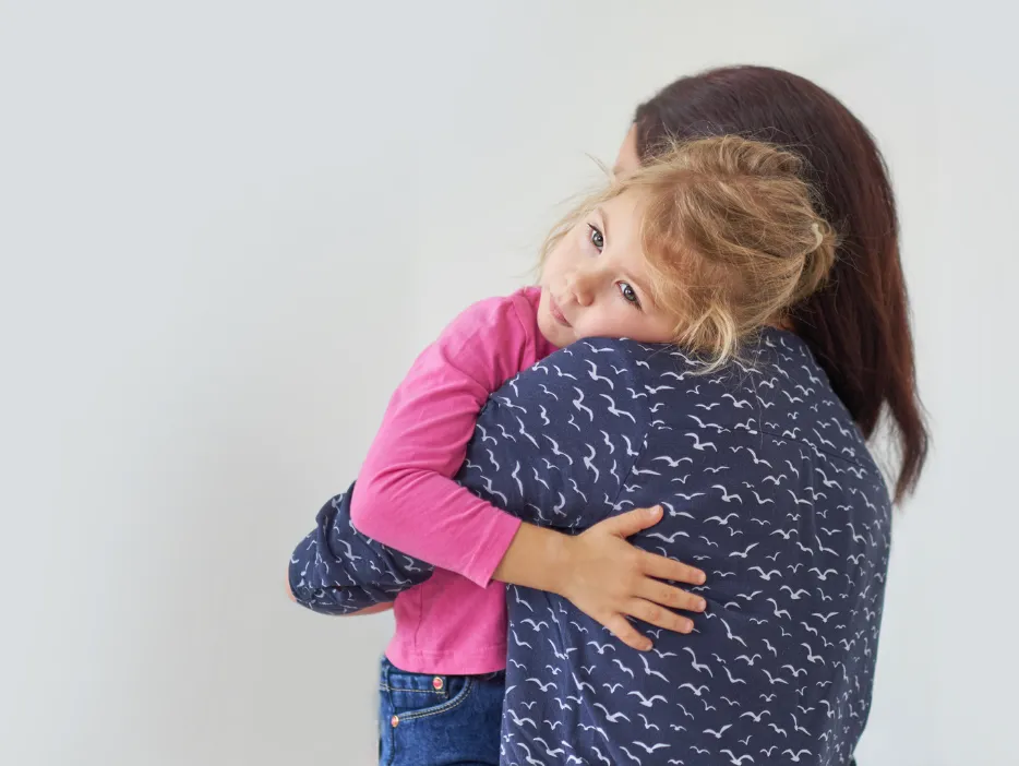 A young child hugging her caregiver